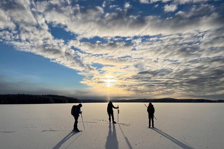 Three skaters enjoy the sunset over the lake.